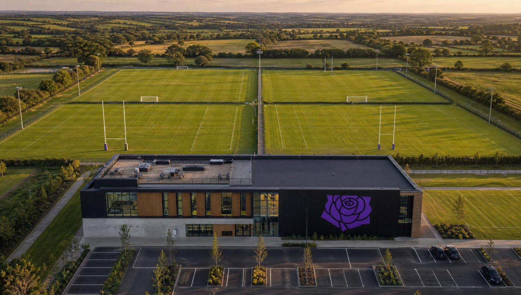 Illustrative aerial render of the proposed Institute showing one integrated building beside four full-size pitches