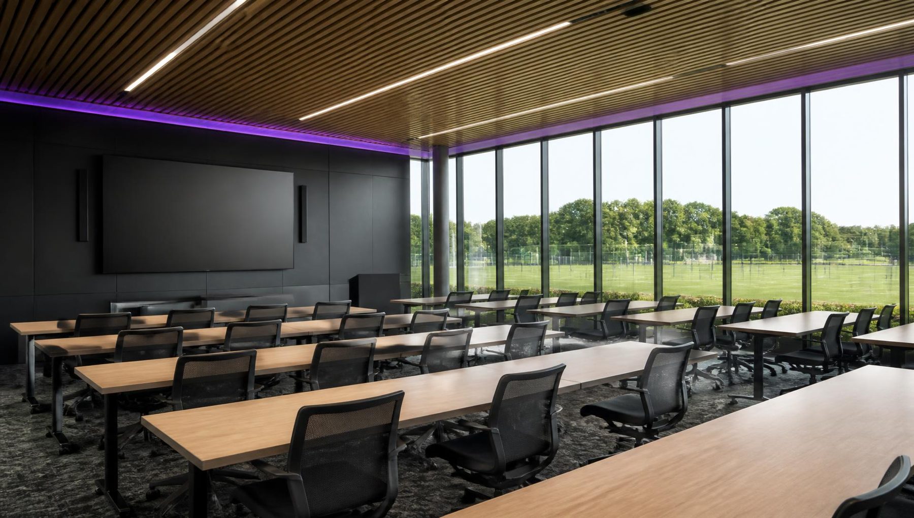 Illustrative render of the proposed education and classroom suite with tiered desks and a large display screen